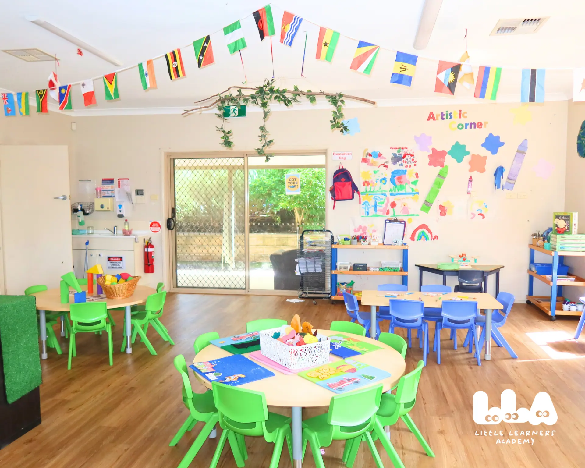 Bright Little Learners Academy classroom with activity tables and world flags